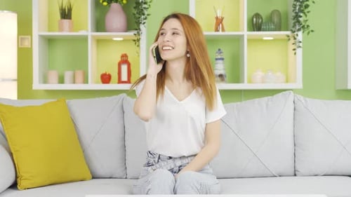Young Woman Talking on Cell Phone at Home
