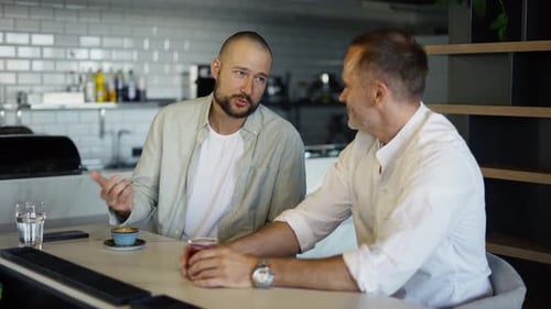 Business Colleagues Having Meeting in a Cafe Elaborating Business Strategy While Viewing Data in