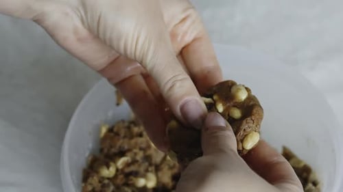 The Woman Kneads And Forms The Dough In Her Hands. Makes Cookies With Peanuts And Chocolate Chips