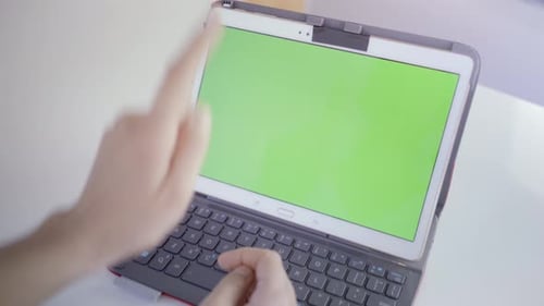 Young caucasian woman in her 30s using her tablet to be online with green screen