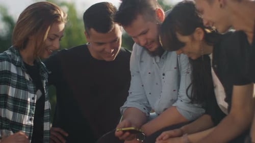Friends Laughing at Smartphone in Urban Park
