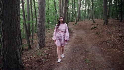 Young Girl In Dress Walking Through The Forest. - full shot