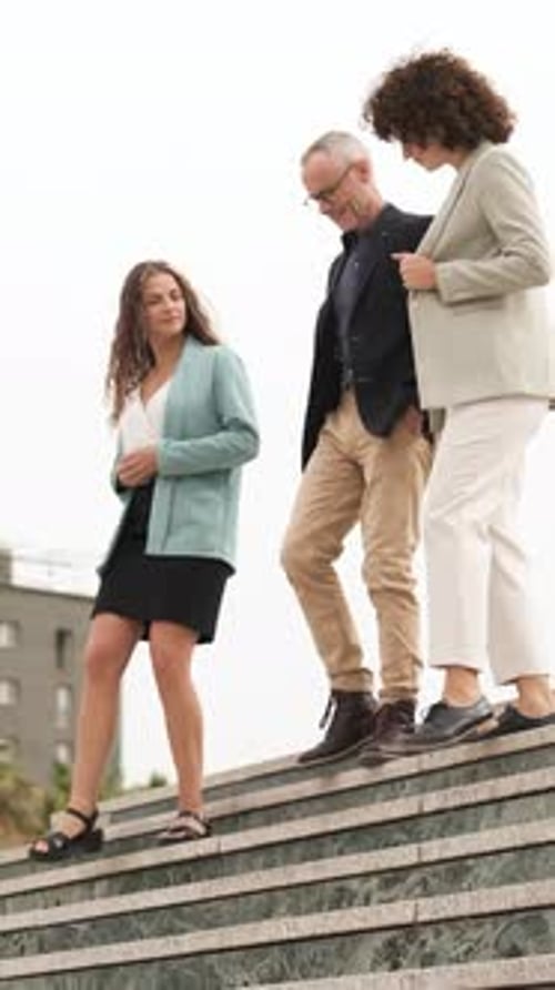 Three Colleagues Walking Down Stairs in City