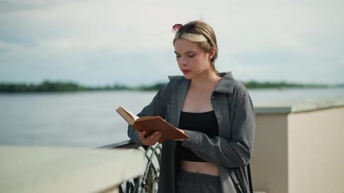 Woman Reading a Book by the River