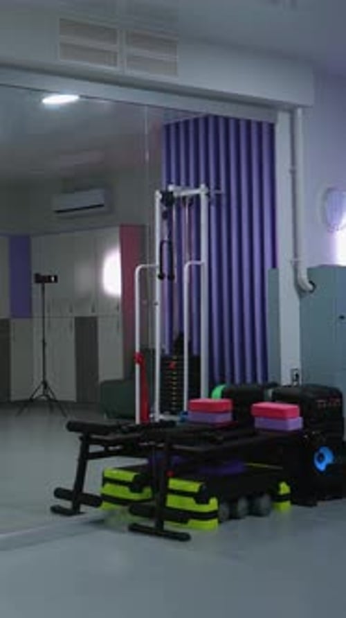 Salle de sport moderne faiblement éclairée avec équipement de fitness en arrière-plan