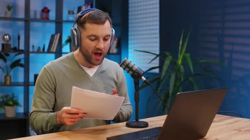 By the laptop. Man with microphone in the studio, conception of podcast.