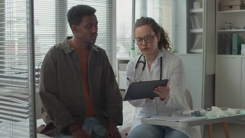Doctor Showing Tablet to Patient in Doctor's Office