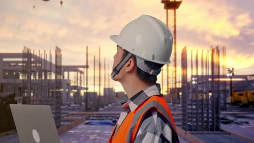 Nahaufnahme eines männlichen asiatischen Ingenieurs, der auf einer Baustelle an einem Laptop arbeitet