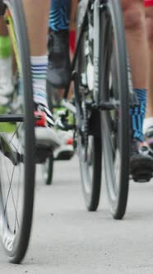 Vertical Screen Shallow Focus Shot of Cyclists Lower Bodies While Riding Bikes