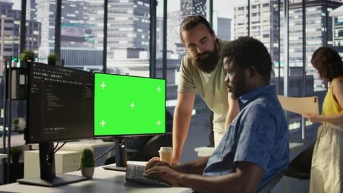 Admin macht Software-Debugging auf einem Greenscreen-PC mit einem Kollegen