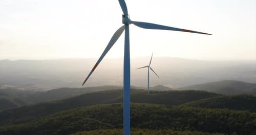 Aerial shot of wind mills rotating by the force of the wind and generating renewable energy in a g