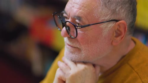 Library Luminary Front View of Senior Man Immersed in Reading