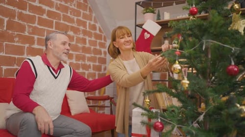 Couple Decorating Christmas Tree at Home