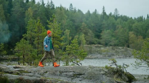 Homme voyageant seul dans la nature pendant un week-end d'automne Joyeux jeune homme adulte marchant sur une rive rocheuse