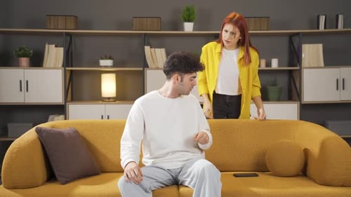 Young Couple Arguing Over Phone on Couch