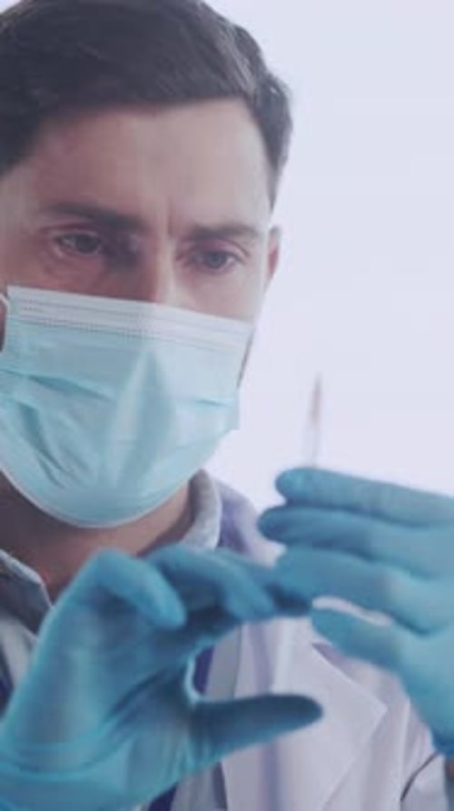 Focused Doctor Preparing a Syringe in Hospital Setting