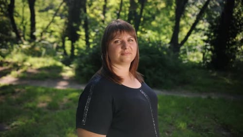 A Smiling Woman Looks Into the Camera at Sunset in a Park an Outdoor Portrait of a Smiling Girl