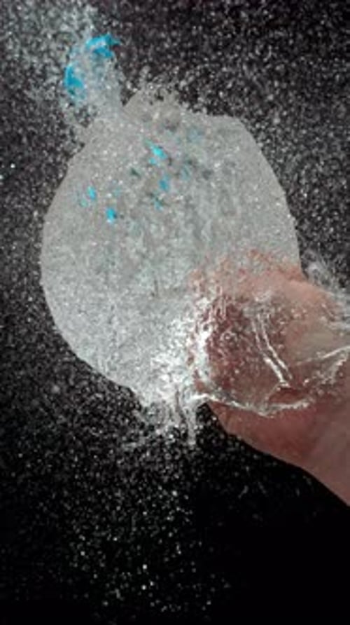 Water Balloon Explosion in Slow Motion Against Black