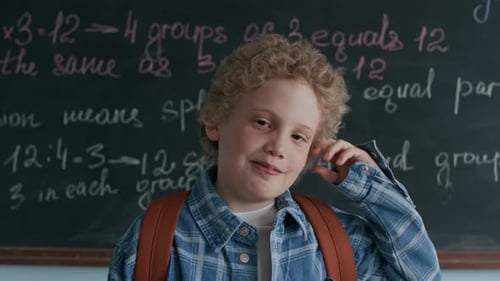 Boy With Backpack Stands by Chalkboard