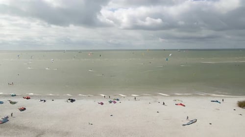 Aerial view of people doing kite surfing along the beach sunny day, Netherlands