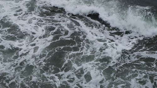 Big splash of waves on foamy sea waters, wide shot in slow motion.