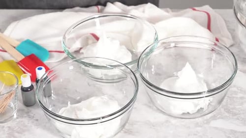 Hands Adding Food Coloring to Three Dessert Bowls