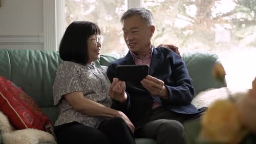 Senior Couple Relaxing Together Looking at a Mobile Phone