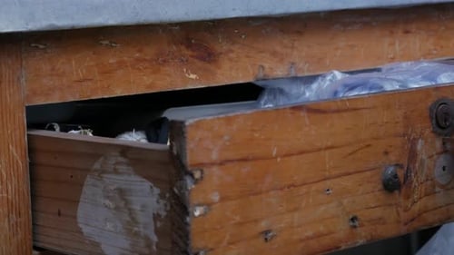 Gros plan de la façade du tiroir en bois patiné avec poignée en métal vintage