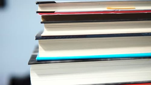 close up book on stack inside room on table - tilt camera