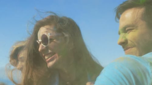 Multi-Ethnic Group of Young People Throw Colorful Powder at Each other in Celebration of Holi Festi