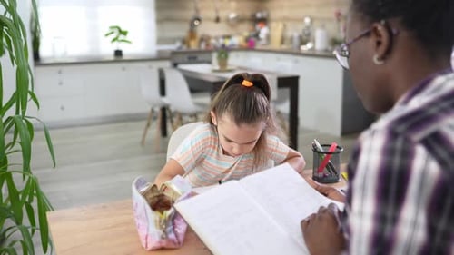 Young Girl Doing Homework with an Adult at Home
