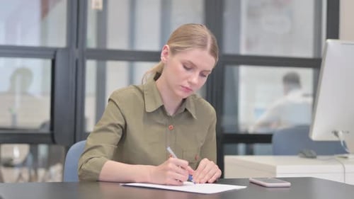 Young Businesswoman Writing a Letter in Office