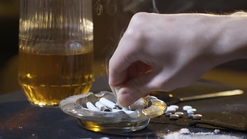 Éteindre une cigarette dans un cendrier.