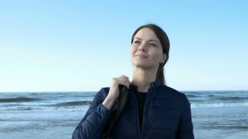 The Pretty Young Lady in Jacket Keep Rucksack, Smile and Walk Close