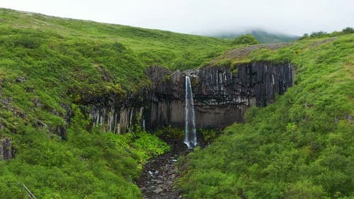 Svartifoss (Black Falls) Waterfall in Skaftafell in Vatnajokull National Park in Iceland - aerial dr