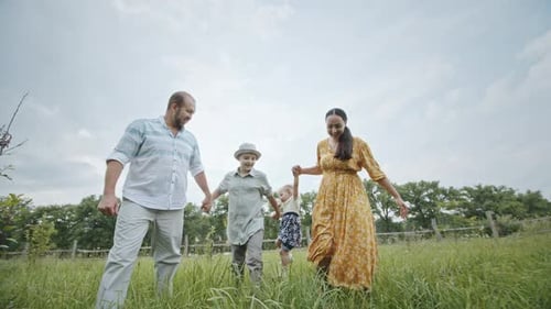Happy Family Walking in a Sunny Field