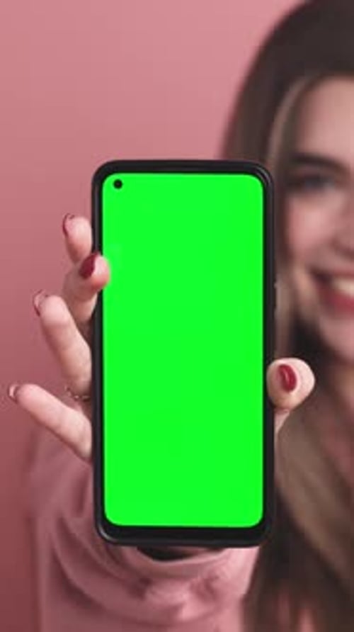 Woman Holds Up Smartphone with Green Screen
