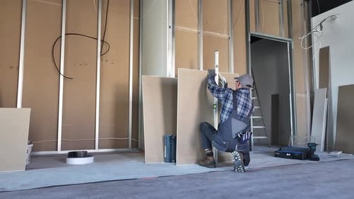 Man Installing Drywall During Construction