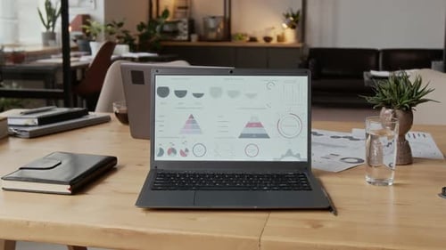 Close-up of Laptop Displaying Business Charts and Graphs in Modern Office