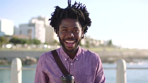 Portrait of trendy businessman taking daily commute, having coffee and enjoying view of the city