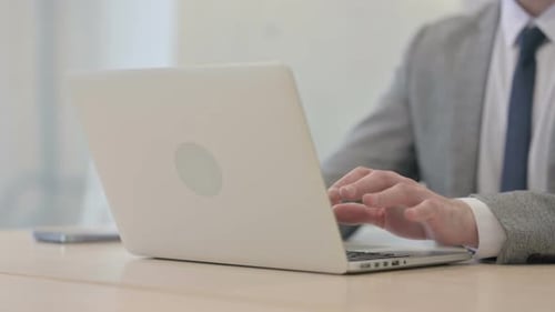 Close up of Young Businessman Typing on Laptop