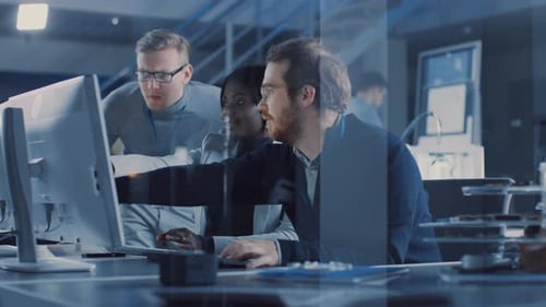 Zwei Elektronikentwicklungsingenieure, die an Computern arbeiten, sprechen mit dem Projektmanager. Das Team von Prof.