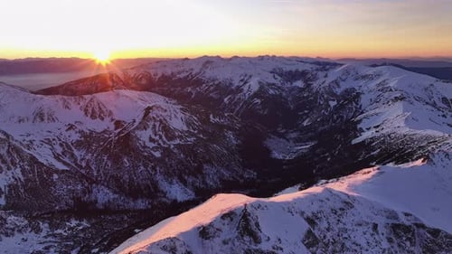 Aerial view of the Alps at sunset with snow-covered peaks