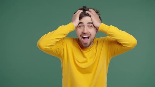 Excited Man With Hands on Head Looks Surprised