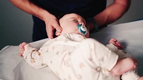 Infant getting chiropractic care on examination table