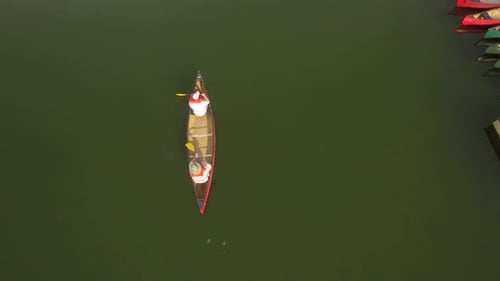 People Ride Kayak on Lake Near a Dock Active People