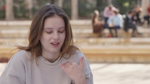 A garota egoísta mostra com um gesto com a mão que não gosta do grupo de pessoas no