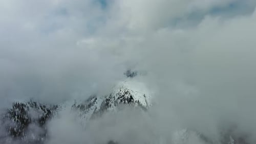 Luftaufnahme der schneebedeckten Berge in Wolken