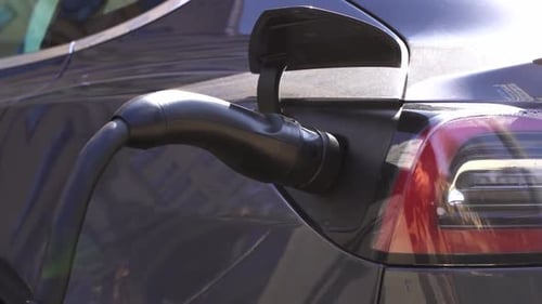 Charging Electric Car on City Street