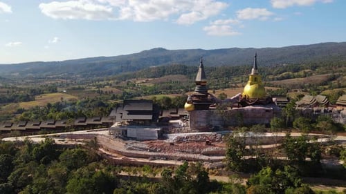 Imagens aéreas deslizando para a direita revelando uma construção massiva de Wat Somdet Phu Ruea, Mi